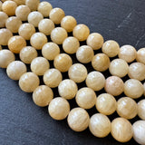 10mm yellow jade beads (undyed) - round - smooth - 16" strand - approx. 35 beads