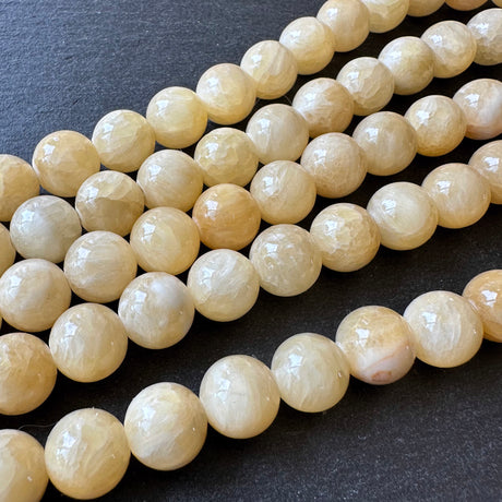 10mm yellow jade beads (undyed) - round - smooth - 16" strand - approx. 35 beads