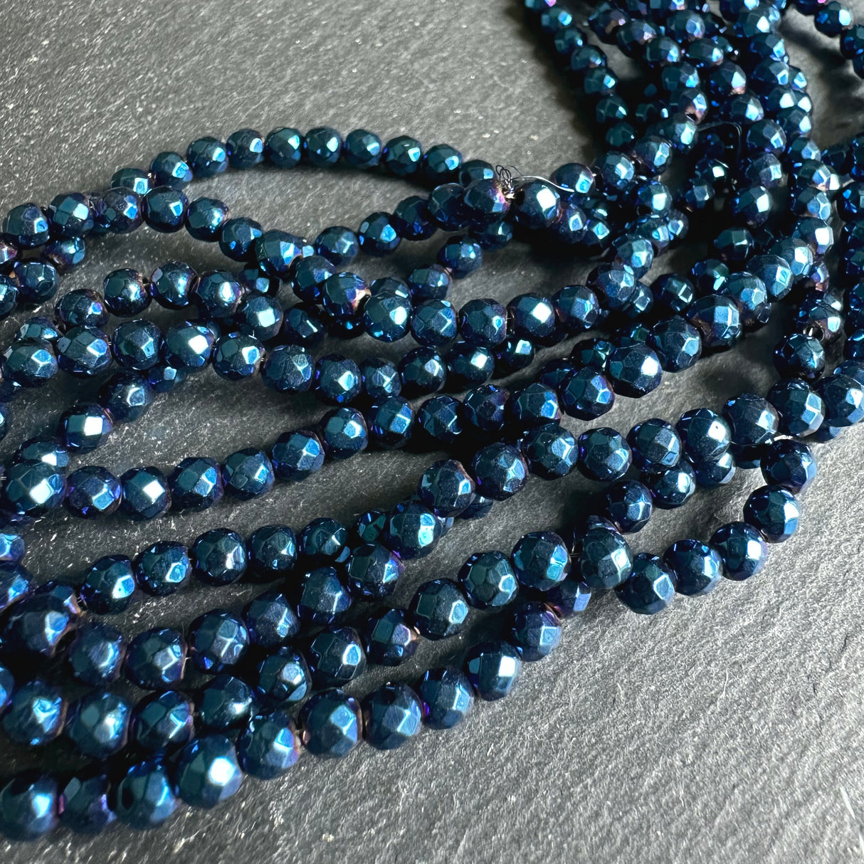 4mm blue electroplated hematite beads - round - faceted - 15" strand - approx. 100 beads