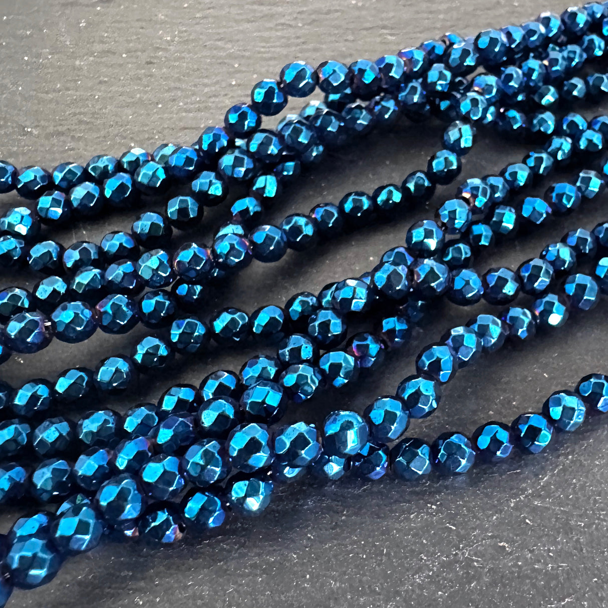 4mm blue electroplated hematite beads - round - faceted - 15" strand - approx. 100 beads