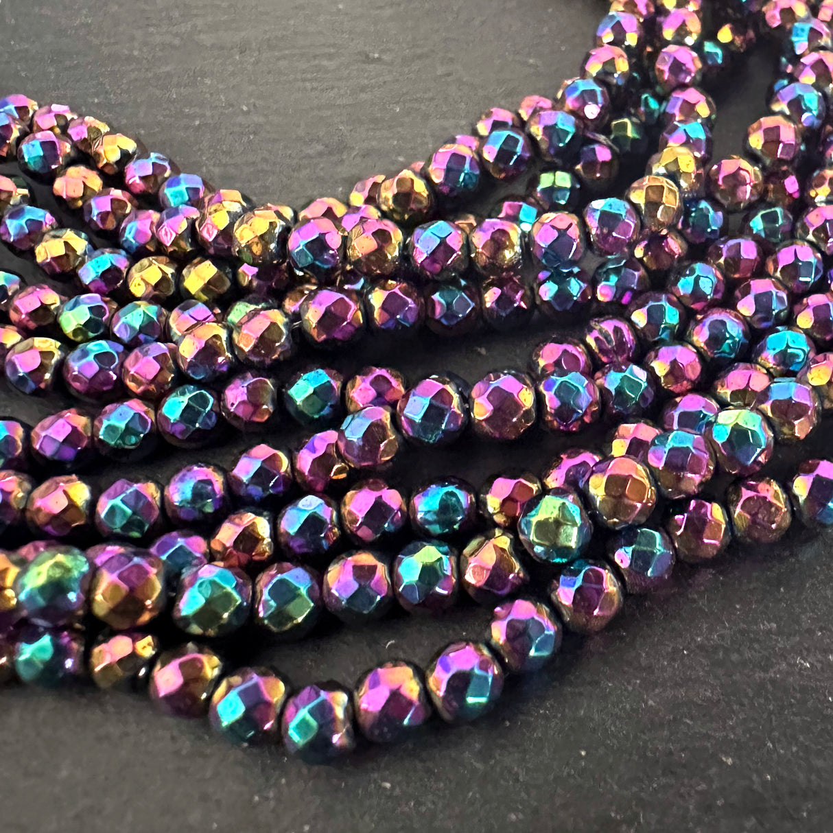 4mm rainbow electroplated hematite - round - faceted - 15" strand - approx. 100 beads