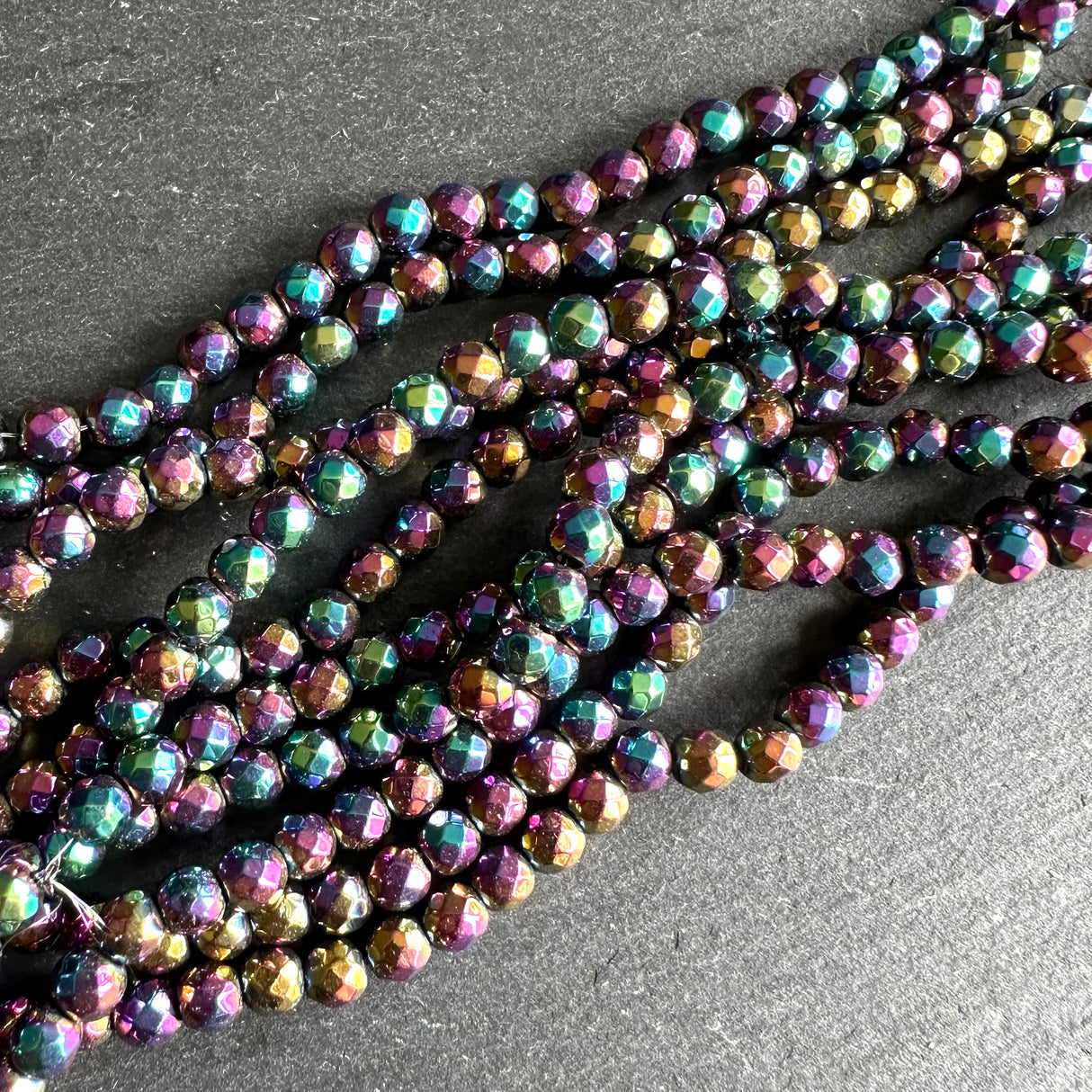 4mm rainbow electroplated hematite - round - faceted - 15" strand - approx. 100 beads