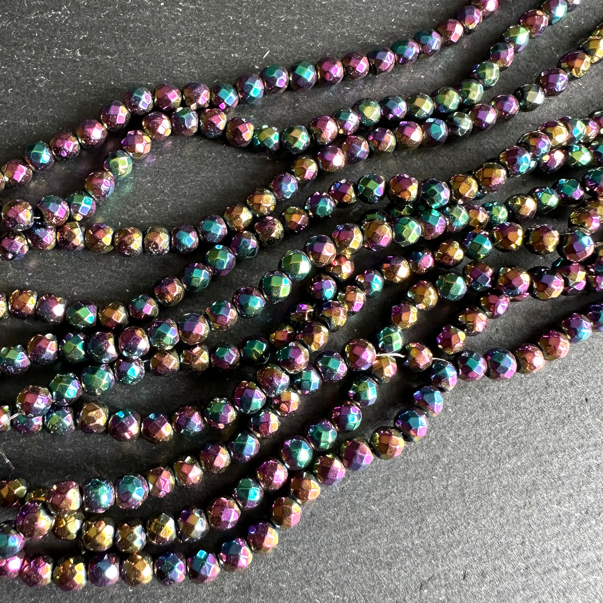 4mm rainbow electroplated hematite - round - faceted - 15" strand - approx. 100 beads