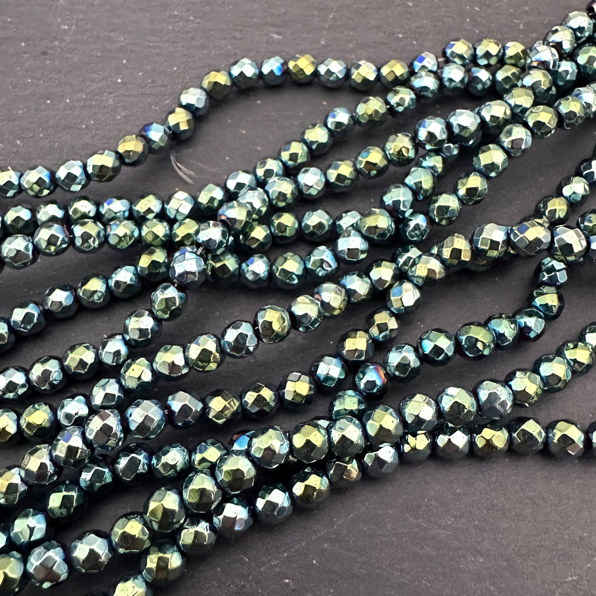 4mm green electroplated hematite beads - round - faceted - 15" strand - approx. 100 beads