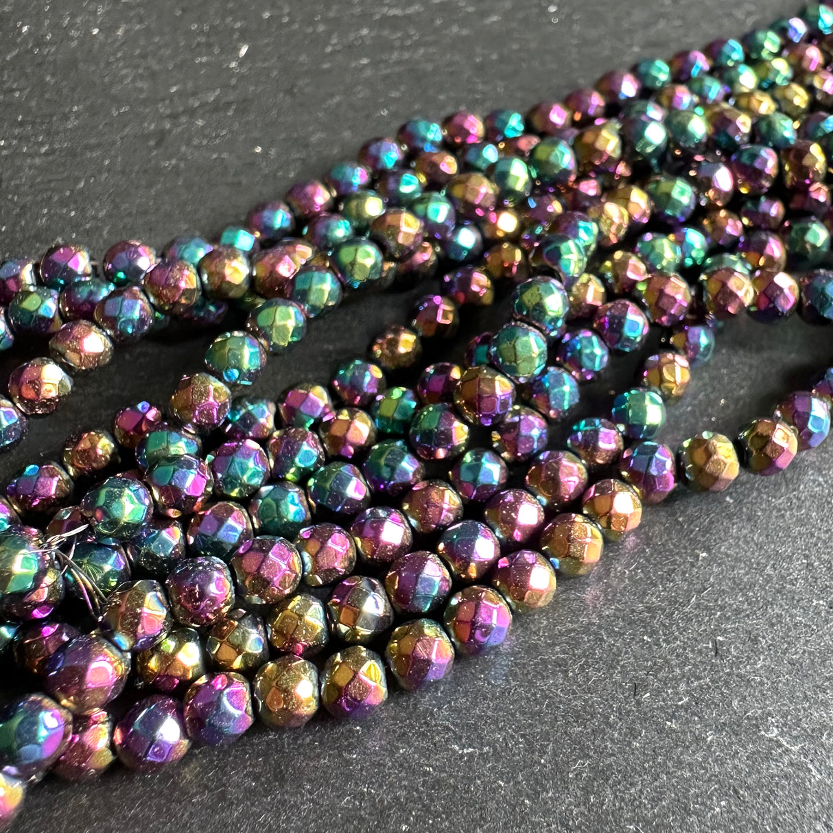 4mm rainbow electroplated hematite - round - faceted - 15" strand - approx. 100 beads